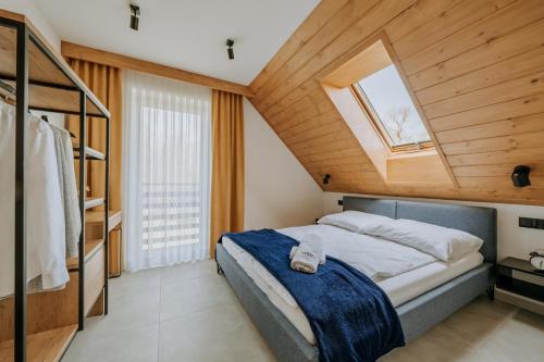 ein Schlafzimmer mit einem großen Bett mit Dachfenster in der Unterkunft Honstryk Relax & Fun Apartamenty z balią i przestrzenią dla rodzin in Krempachy