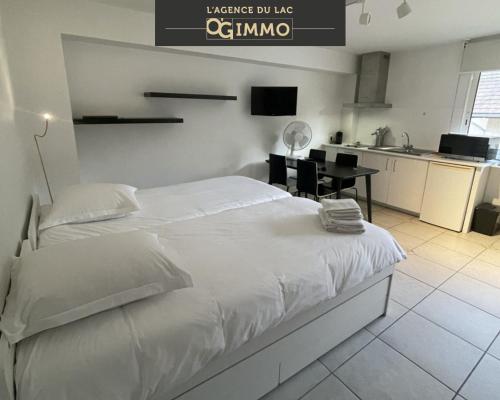 una camera con un grande letto bianco e una cucina di Petit Lac a Duingt