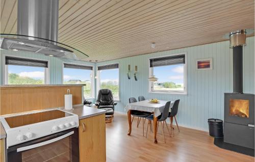 a kitchen and dining room with a table and a stove at Holiday Home Vinderup 5 in Vinderup