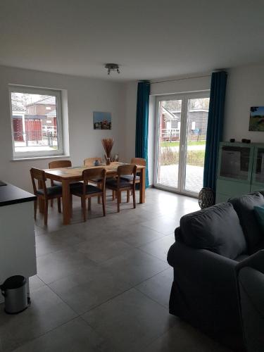 a living room with a table and chairs and a couch at Wunderschönes Appartement in Fedderwardersiel mit Terrasse in Butjadingen