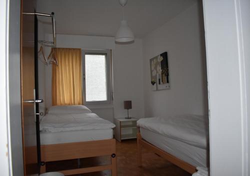 a bedroom with two beds and a window at Ruhiger Vorort Bern kostenloses Parken 6km Zentrum in Zollikofen