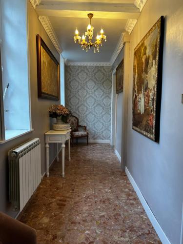 a hallway with a painting on the wall and a chandelier at Château le Withof in Bourbourg