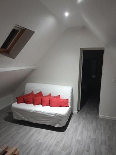 - un canapé blanc avec des oreillers rouges dans l'établissement Maison a côté du pal, à Saligny-sur-Roudon
