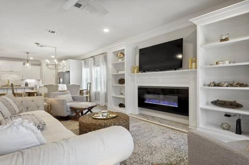 a living room with a couch and a tv at Luxury home walkable to the beach in Gulfport