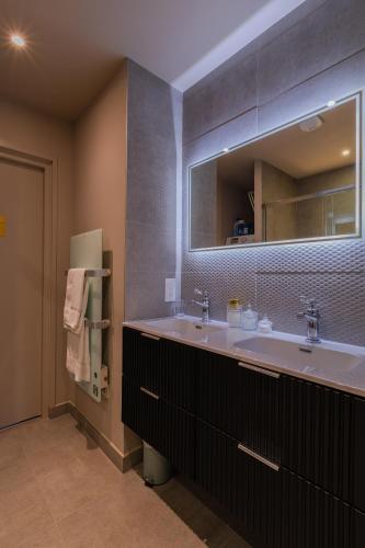 une salle de bain avec un grand lavabo et un miroir dans l'établissement Villa & Spa Kyo-Alpes, piscine intérieures privées-Belledonne, à La Combe-de-Lancey