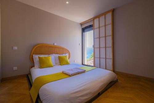 una camera da letto con un letto grande con una grande finestra di Villa & Spa Kyo-Alpes, piscine intérieures privées-Belledonne a La Combe-de-Lancey