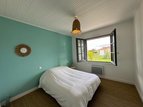 une chambre avec un lit blanc et une fenêtre dans l'établissement Oyat, à Saint-Hilaire-de-Riez