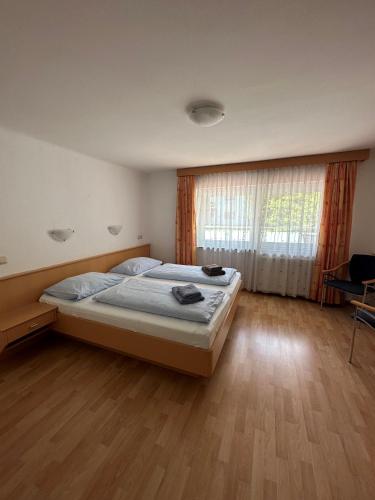 a bedroom with a large bed and a wooden floor at Pension Monika, Cozy B&B, newly renovated rooms in Kaprun in Kaprun
