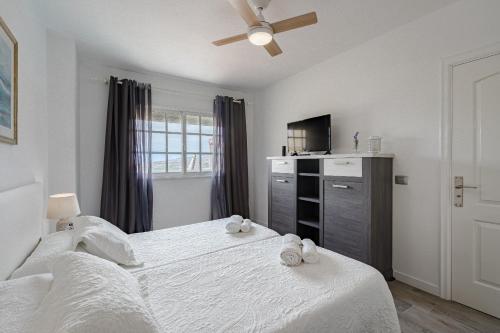 Un dormitorio con una cama grande con toallas. en Balcon Smart Home Hi-End Services Media Streaming, en Adeje