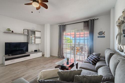 Una sala de estar con un sofá y un televisor de pantalla plana. en Balcon Smart Home Hi-End Services Media Streaming, en Adeje
