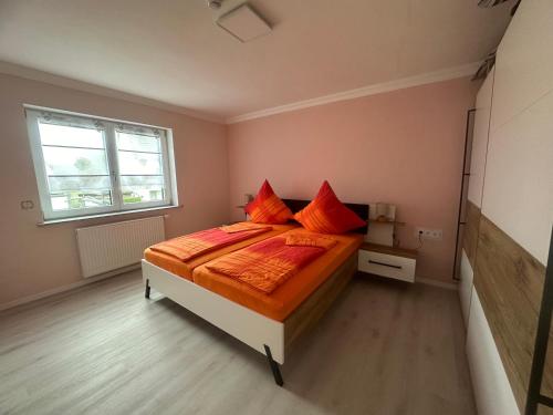 a bedroom with a bed with red pillows on it at Ferienwohnung Hochwaldblick 5 in Morbach