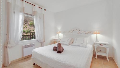 une chambre blanche avec un lit et une fenêtre dans l'établissement LES CIGALES, Superbe vue - Golfe de Sainte-Maxime, à Sainte-Maxime