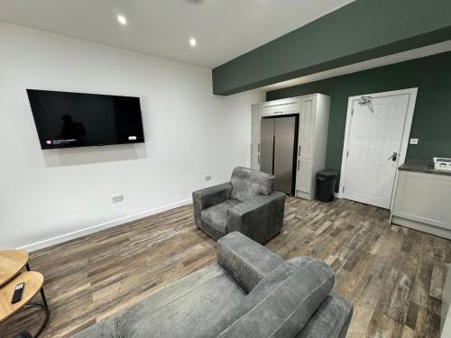 a living room with two couches and a flat screen tv at Staywell Hartlepool in Hartlepool