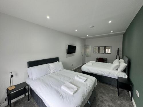 1 Schlafzimmer mit 2 Betten und einer grünen Wand in der Unterkunft Staywell Hartlepool in Hartlepool