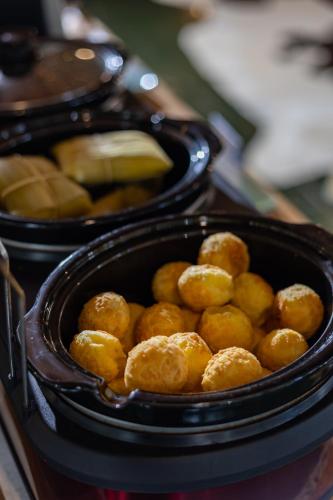 a container filled with fried food on top of a stove at Pousada Cantos e Contos in Monte Verde