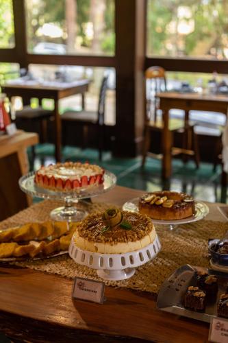 a table with cakes and other pastries on it at Pousada Cantos e Contos in Monte Verde
