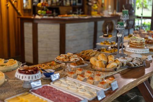 a buffet with many different types of food on a table at Pousada Cantos e Contos in Monte Verde