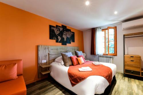 a bedroom with a large bed with orange walls at Logis L'Auberge de Larressingle in Larressingle