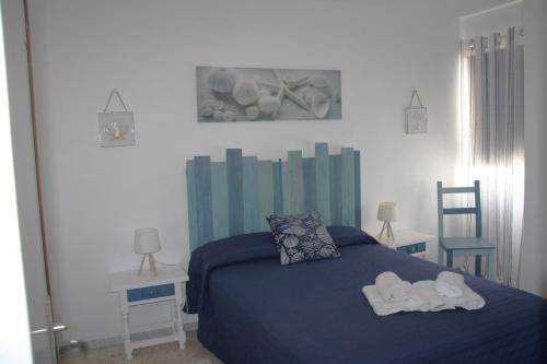a bedroom with a blue bed with towels on it at APTO 1103 MESA DEL MAR in Puerto de la Madera
