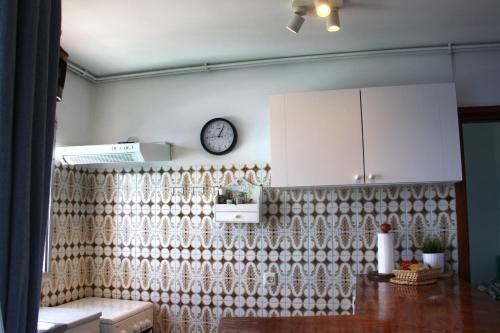 a kitchen with a curtain and a clock on the wall at APTO 1103 MESA DEL MAR in Puerto de la Madera