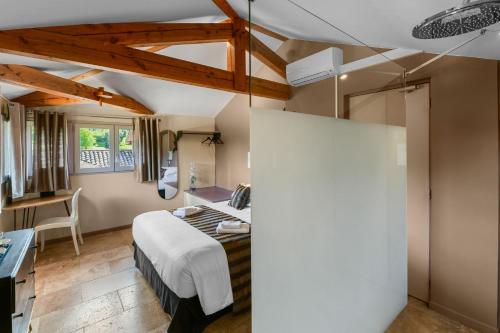 a bedroom with a bed and a desk in a room at Logis L'Auberge de Larressingle in Larressingle