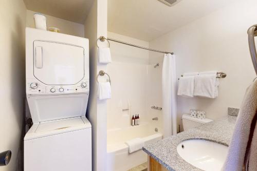 een badkamer met een wasmachine en droger naast een wastafel bij Ski Bowl Condos Unit 518 in Truckee
