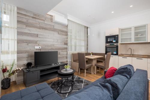 a living room with a blue couch and a kitchen at Amelia & Julia apartments in Rijeka