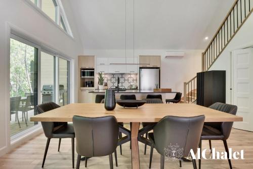a kitchen and dining room with a wooden table and chairs at Sunset - Cosy boisé - Spa in Pont-Rouge