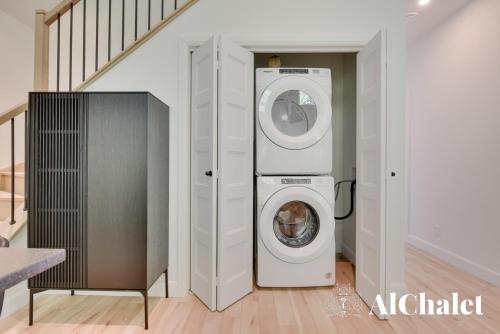 a laundry room with a washing machine next to a staircase at Sunset - Cosy boisé - Spa in Pont-Rouge