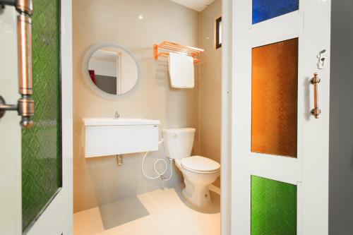 a bathroom with a toilet and a sink and a mirror at Cloud 9 Lodge in Bangkok