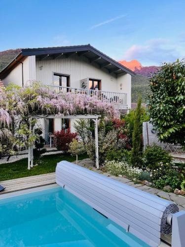 une maison avec une piscine devant une maison dans l'établissement Hygge Lodge Annecy, à Doussard