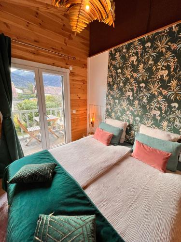 une chambre avec deux lits et une grande fenêtre dans l'établissement Hygge Lodge Annecy, à Doussard