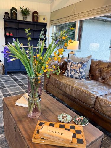 a living room with a couch and a table with flowers at Balmridge House, Loch Ness, Bed & Breakfast in Drumnadrochit
