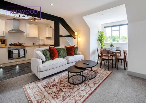 a living room with a white couch and a table at Comfortable and Homely 1-Bedroom 1-Bathroom Serviced Apartment, Free Parking, Free WiFi By Redwood Stays in Farnborough