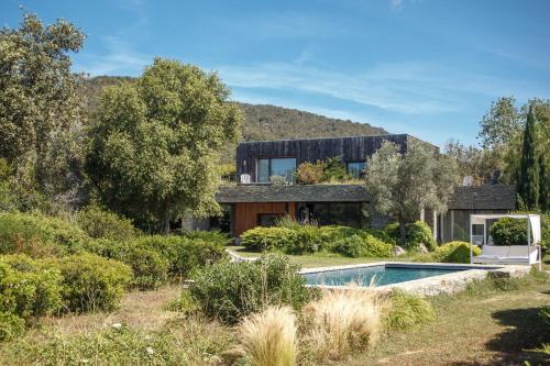 une maison avec une piscine dans un jardin dans l'établissement Les lofts de palombaggia, à Porto-Vecchio