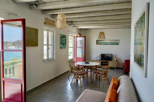 a living room with a couch and a table and chairs at Follow Your Art in Kýthira