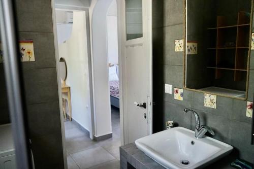 a bathroom with a sink and a mirror at Follow Your Art in Kýthira