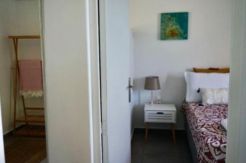 a bedroom with a bed and a table with a lamp at Follow Your Art in Kýthira