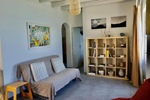 a living room with a couch and a book shelf at Follow Your Art in Kýthira