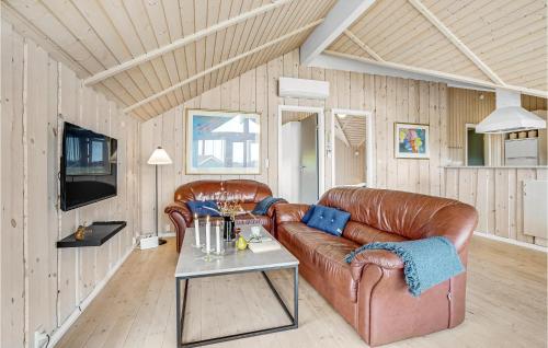 a living room with a leather couch and a table at Stunning Home In Vinderup With Sauna in Vinderup
