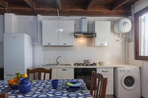 a kitchen with white cabinets and a table with fruit on it at Casa Ezio 2 fronte mare a Punta Grossa di Punta Prosciutto in Punta Prosciutto