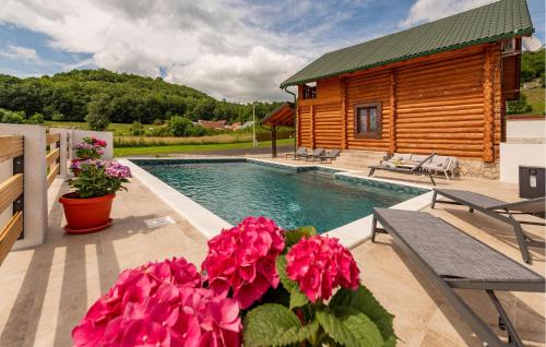 una casa con piscina e alcuni fiori e una cabina di Kolibe Lika - The Valley a Mušaluk
