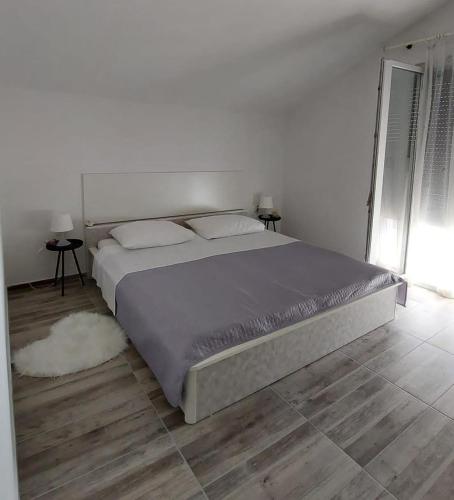 a bedroom with a large bed in a white room at Apartments Marija with big garden - TA Leut Agency in Vrsi