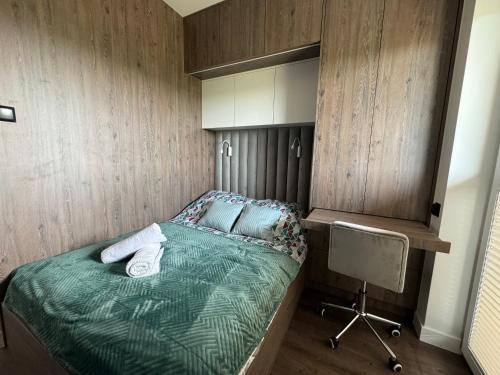 a small bedroom with a bed and a chair at VIP Apartament Kopisto CENTRUM in Rzeszów