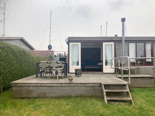 a patio with a table and chairs on a house at Chalet im Hafen mit Angelsteg infrarotsauna in Anjum