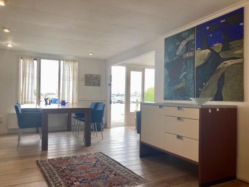 a dining room with a table and blue chairs at Chalet im Hafen mit Angelsteg infrarotsauna in Anjum
