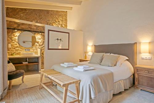 a bedroom with a bed and a chair and a mirror at CAN SAFRA in La Pera