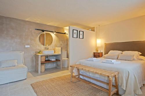 a bedroom with a bed and a chair and a mirror at CAN SAFRA in La Pera