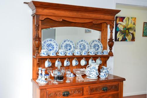 a wooden cabinet with blue and white dishes on it at Torquay Terrace Bed & Breakfast in Hervey Bay
