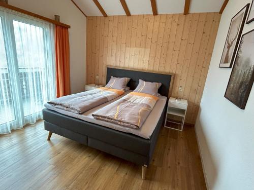 a bed in a room with a large window at Chalet Gerbera in Wengen